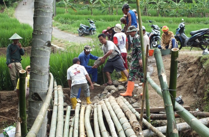 JEMBATAN BAMBU : Pembangunan jembatan darurat dari bambu di Sungai Citalaga Desa Negarajati yang ambruk tergerus luapan air saat hujan deras, Selasa (10/3)/TASLIM INDRA