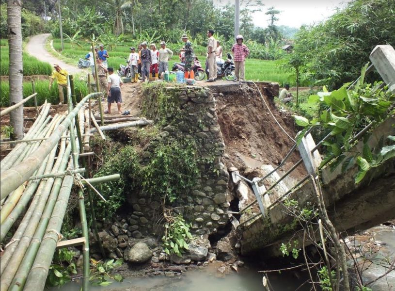 Warga bersama Perangkat Desa Negarajati, dibantu anggota Koramil dan Polsek Cimanggu membuat jembatan darurat di samping jembatan yang putus