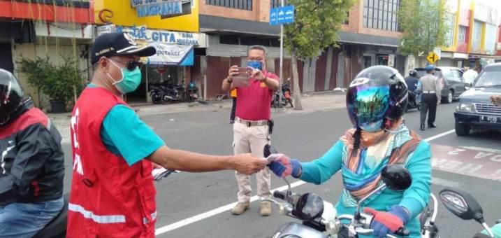 BAGIKAN MASKER: Wakil Bupati Banyumas Sadewo Tri Lastiono menyerahkan masker kepada pengendara motor.