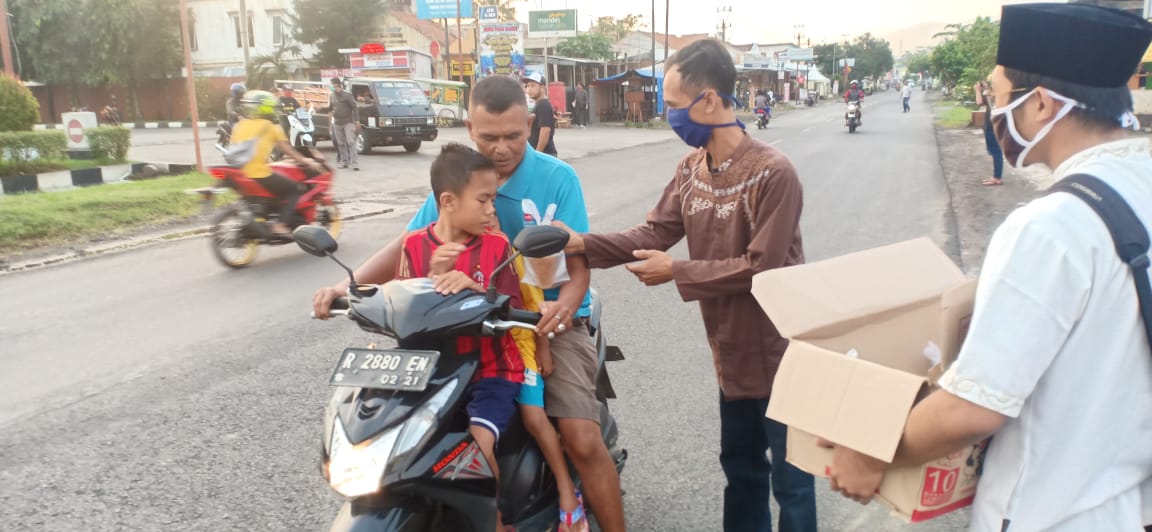 BAGI TAKJIL: Anggota Komunitas King Cimanggu, Raciber bagi-bagi takjil gratis kepada pengguna jalan di Jalan Raya Cimanggu Kecamatan Cimanggu Kabupaten Cilacap.Jum’at (15/5).