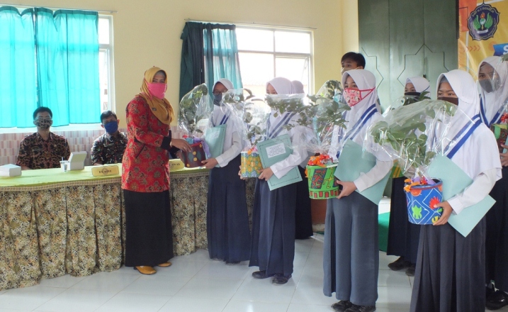 Kepala SMP Negeri 2 Sidareja Lely Dianawati SPd menyerahkan hadiah dan kenang-kenangan satu batang benih pohon Jambu kepada 10 siswa yang masuk dalam 10 besar perolehan nilai ujian sekolah terbaik. (Foto/TASLIM INDRA/BANYUMAS EKSPRES)