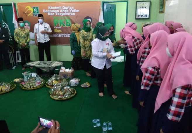 SANTUNAN : Siti Mukaromah memberikan santunan kepada anak yatim dalam acara peringatan harlah PKB ke 22 di DPC PKB Banyumas, Kamis ( 23/7).