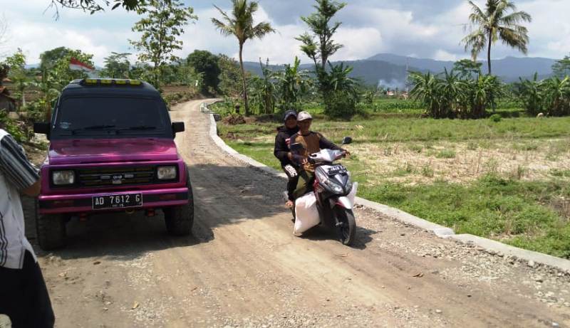 MANFAATKAN JALAN: Petani mulai memanfaatkan Jalan TMMD Reguler 109 Kodim 0713 Brebes untuk mengangkut hasil pertanian menggunakan sepeda motor.
