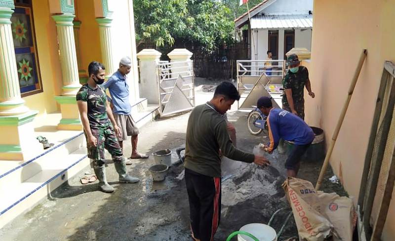 BANTU: Anggota TNI menyempatkan waktu membantu masyarakat Dukuh Karanganyar yang sedang merenovasi sanitasi di Masjid Darussalam, Dukuh Karanganyar.